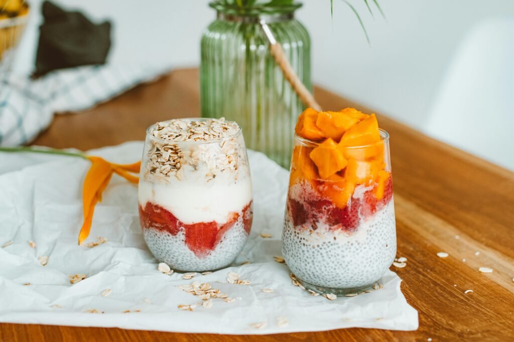 Delicious chia seed parfaits topped with mango, strawberries, and oats in a cozy setting.